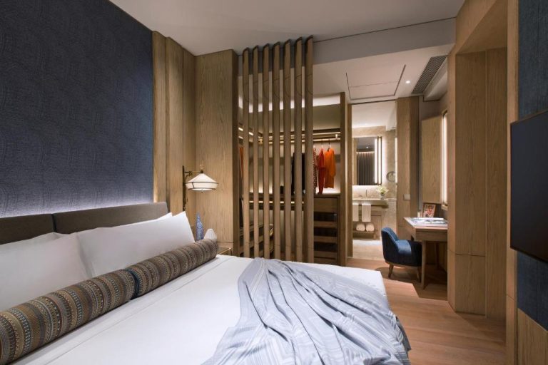 Habitación superior del K11 ARTUS con cama doble, vestidor integrado y zona de escritorio en madera