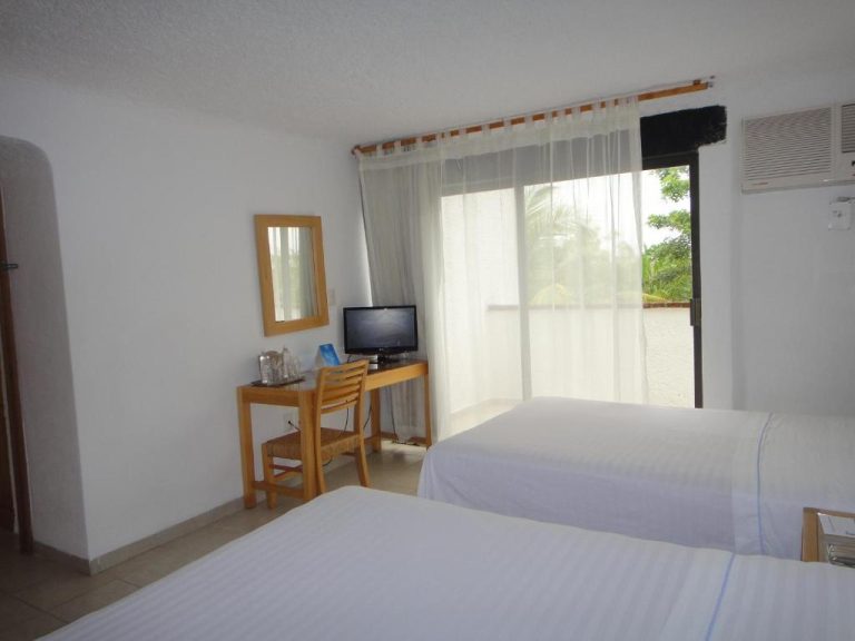 Habitación doble con dos camas, escritorio y balcón con vistas al jardín en Sotavento Hotel & Yacht Club