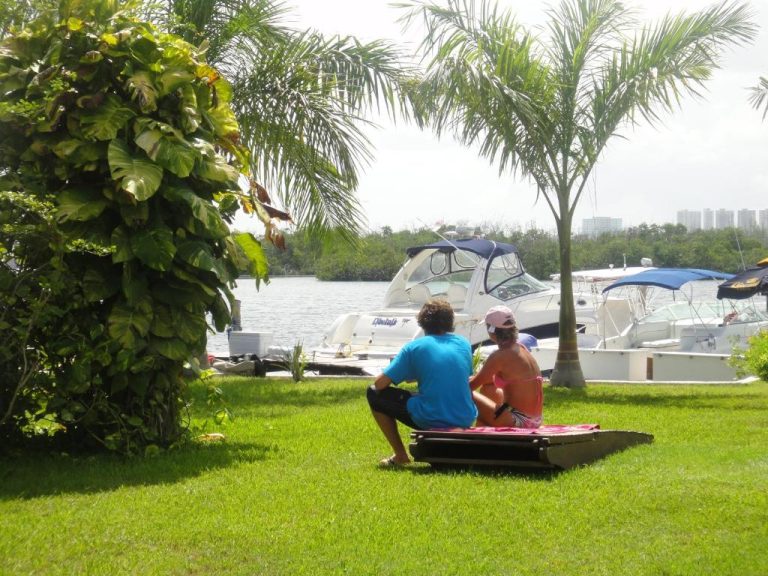 Pareja relajándose en el jardín frente a la marina del Sotavento Hotel & Yacht Club