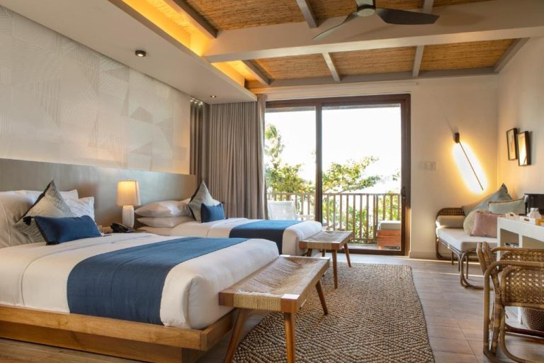 Habitación doble con balcón y vistas al jardín en Maremegmeg Beach Club, decoración tropical moderna