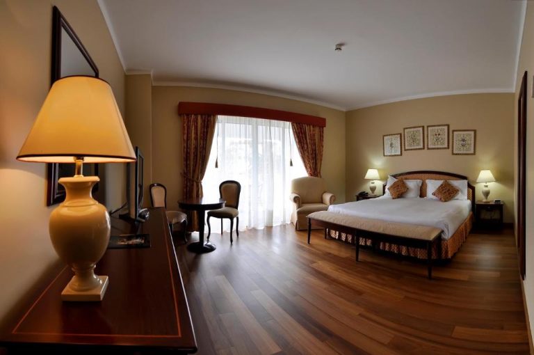 Habitación suite de lujo con cama doble y suelo de madera en Hotel Talisman