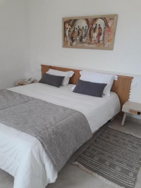 Habitación doble con cama grande y decoración minimalista en Les Jardins de Toumana