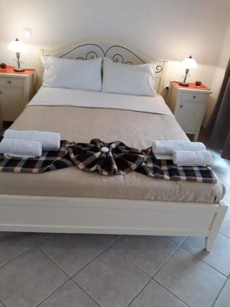 Habitación doble con cama matrimonial y toallas decoradas en Pulades Resort