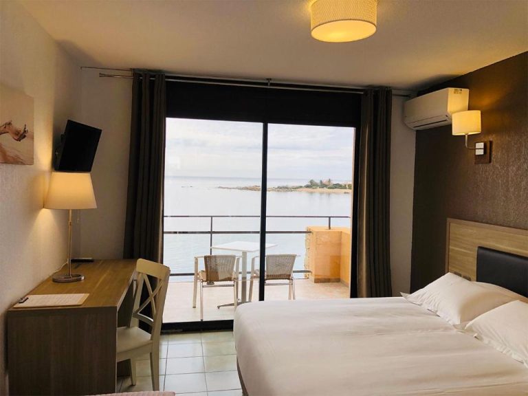 Habitación doble con balcón y vista al mar en el Hôtel du Golfe, con escritorio y cama