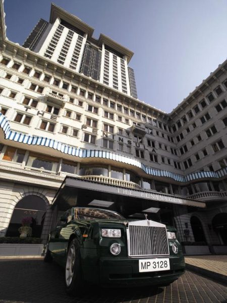 Rolls-Royce verde aparcado frente a la entrada principal del lujoso hotel The Peninsula Hong Kong