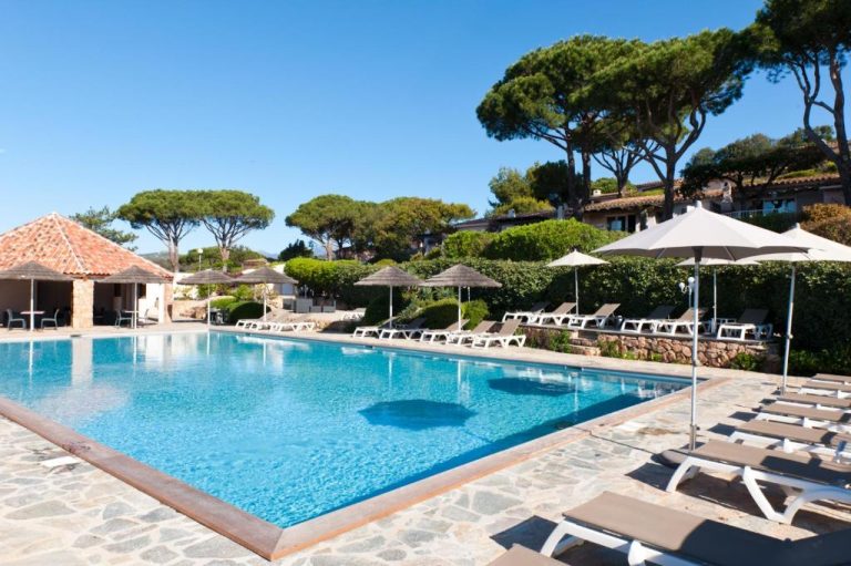Piscina exterior con tumbonas y sombrillas de la Résidence Marina Di Santa Giulia en Córcega