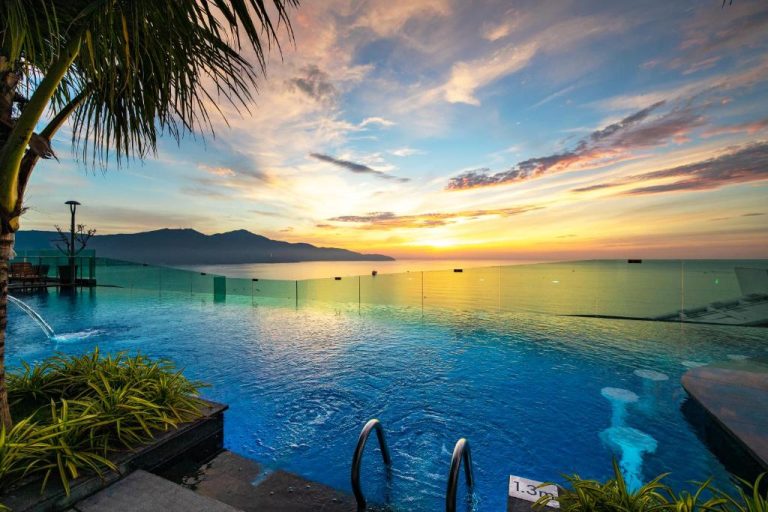 Piscina infinita con vistas al mar y atardecer dorado en el Sala Danang Beach Hotel, Vietnam