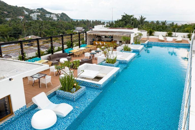 Piscina infinita en la azotea del Ferra Hotel and Garden Suites con zona lounge y vistas al mar