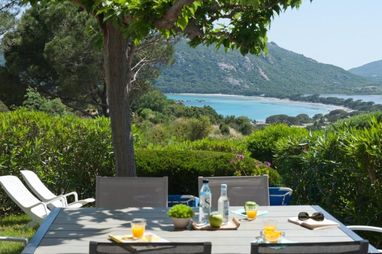 Terraza con mesa y vistas al mar turquesa en Résidence Marina Di Santa Giulia, Córcega
