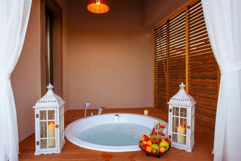 Jacuzzi romántico con velas y frutas frescas en el Arwen Hotel, decorado con linternas blancas
