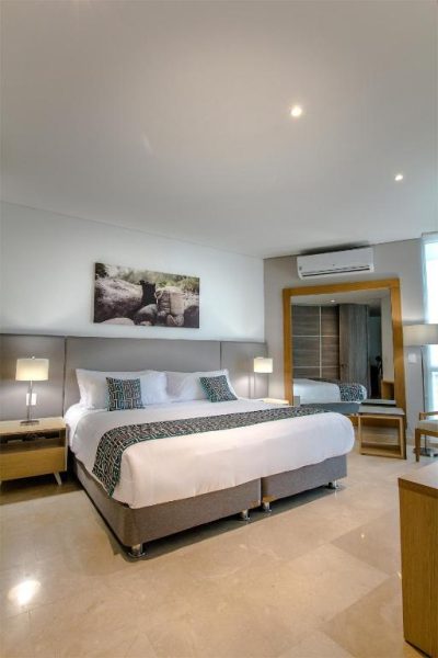 Habitación doble superior con cama king size y decoración moderna en Grand Marina Suites Santa Marta