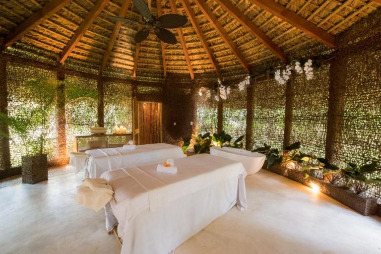 Cabana de spa con dos camillas de masajes y techo de palma en el hotel Sublime Samaná