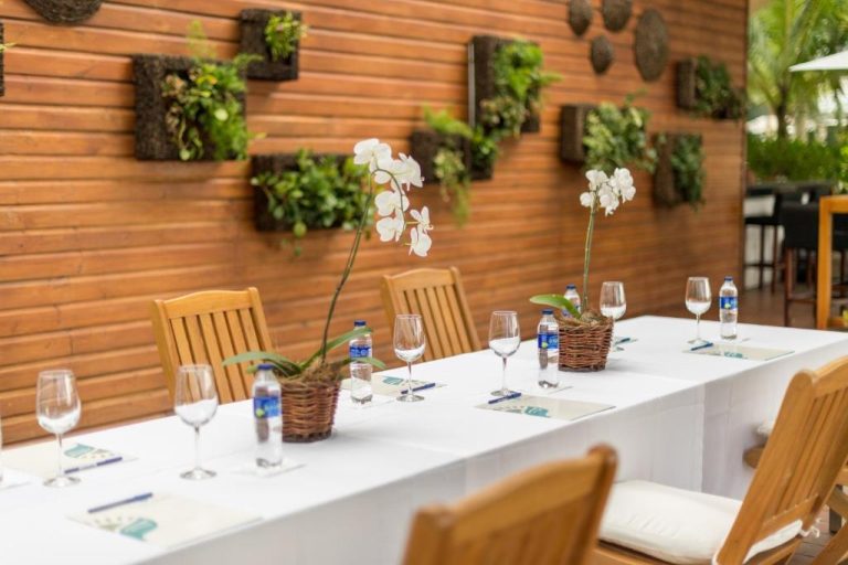 Salón de eventos al aire libre con mesa decorada con orquídeas blancas en Hotel Sublime Samaná