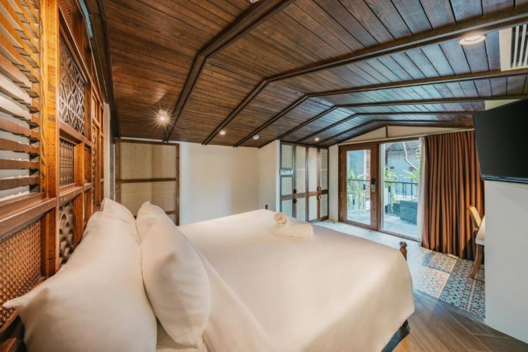 Habitación de lujo con techo de madera y cama doble en Minh Boutique Hotel con balcón exterior