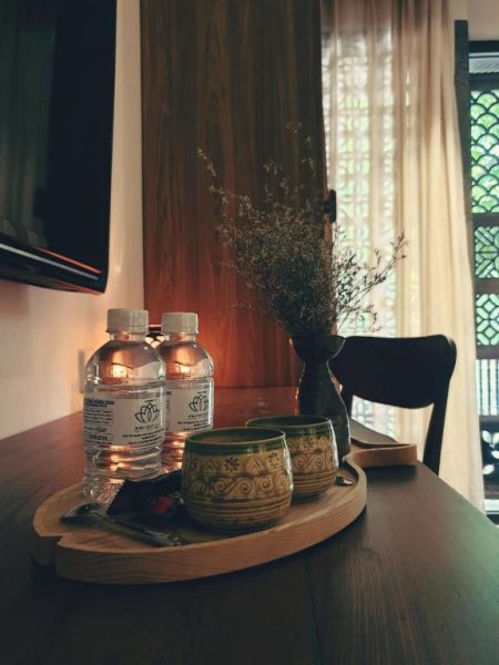 Mesa de bienvenida con tazas de té, agua y decoración floral en Minh Boutique Hotel