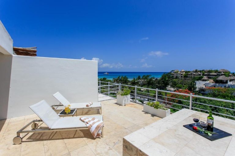 Terraza privada con tumbonas y vista al mar turquesa en Magia Beachside Condo Playa del Carmen