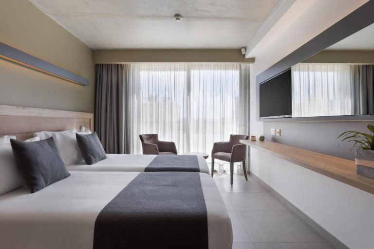 Habitación twin moderna con televisión y vistas al exterior en Azur Hotel by ST Hotels