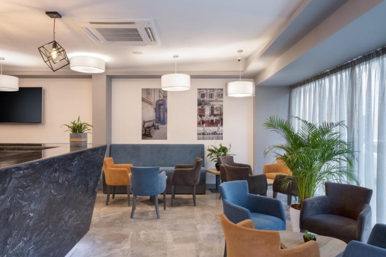 Salón lobby del Azur Hotel by ST Hotels con sillones azules y amarillos, iluminación moderna y plantas decorativas