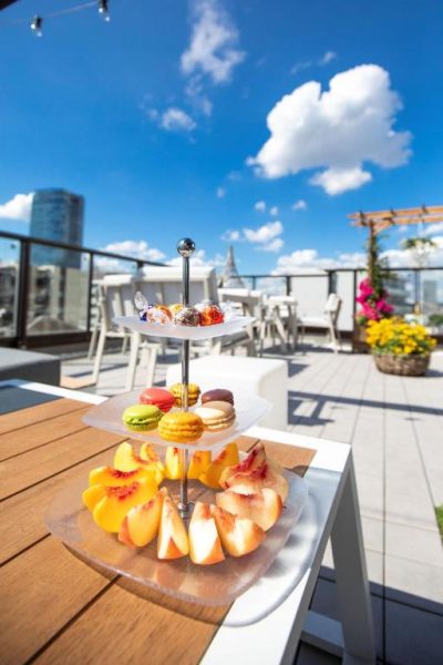 Bandeja de afternoon tea con frutas frescas y macarons en la terraza exterior del Sola Hotel