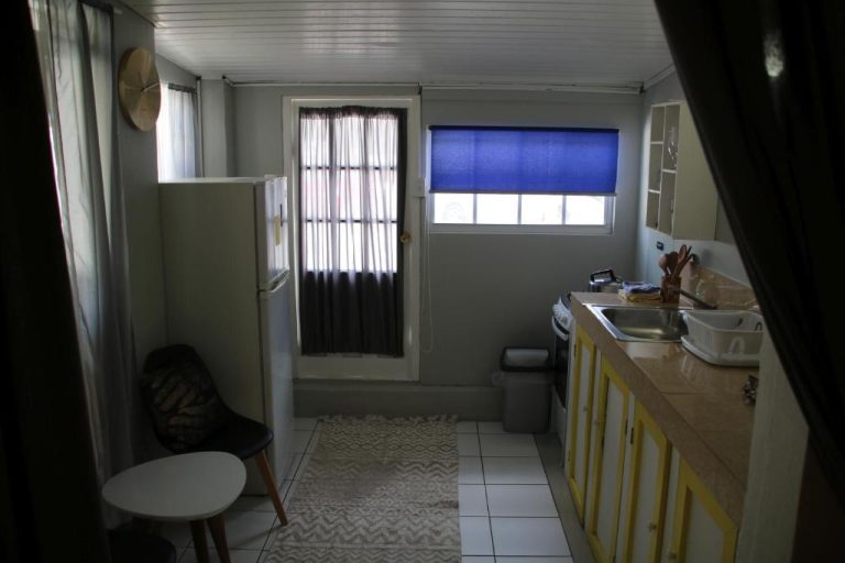 Cocina equipada con nevera, fregadero y gabinetes amarillos en Coral Reef Beach