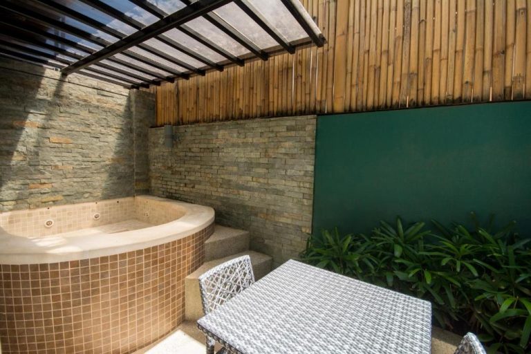 Jacuzzi exterior con mosaico y paredes de bambú en Boracay Haven Suites, zona de relax privada
