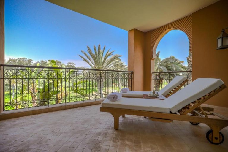 Terraza privada con tumbonas y vistas al jardín tropical en Tikida Golf Palace Marrakech