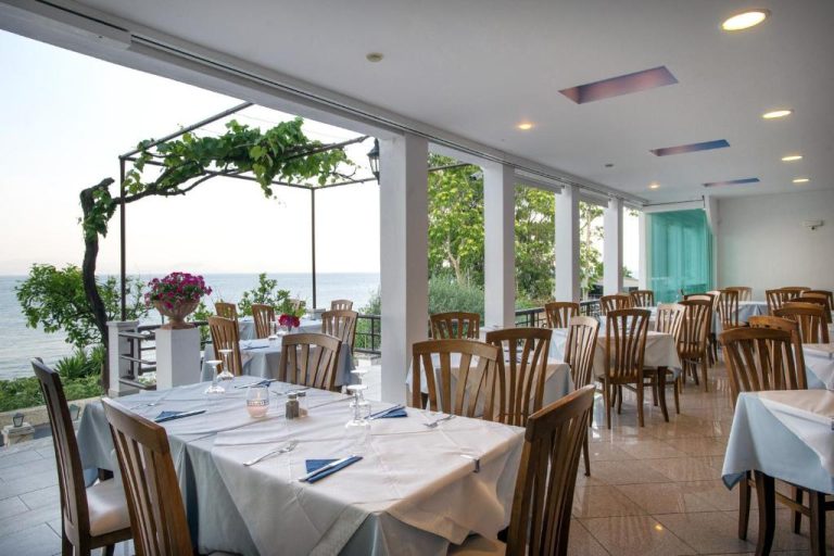 Restaurante con terraza y vistas al mar del Hotel Kaiser Bridge, mesas con mantel blanco