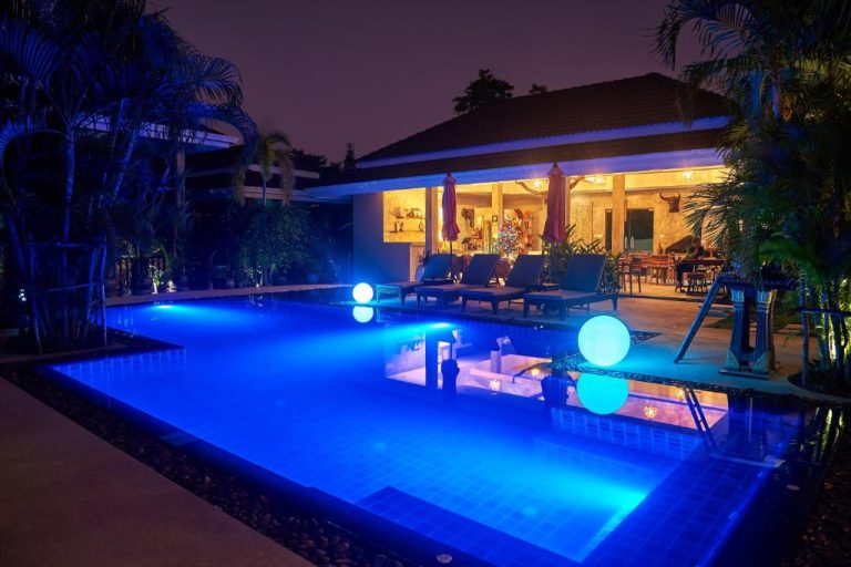 Piscina iluminada de noche con esferas flotantes en Baan Sawan Samui Resort, Tailandia