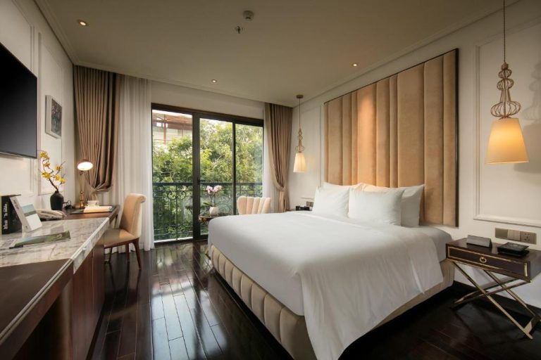 Habitación deluxe con cama king size y balcón con vistas al jardín en Anatole Hotel Hanoi