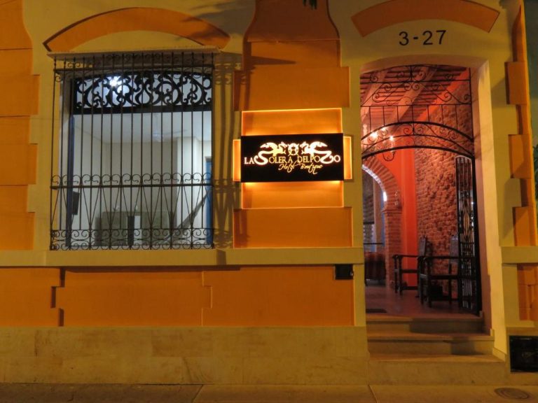 Fachada nocturna con entrada principal del Hotel Boutique La Solera Del Pozo con iluminación cálida