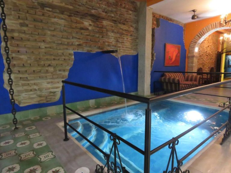 Piscina interior con cascada y decoración de ladrillo visto en Hotel Boutique La Solera Del Pozo