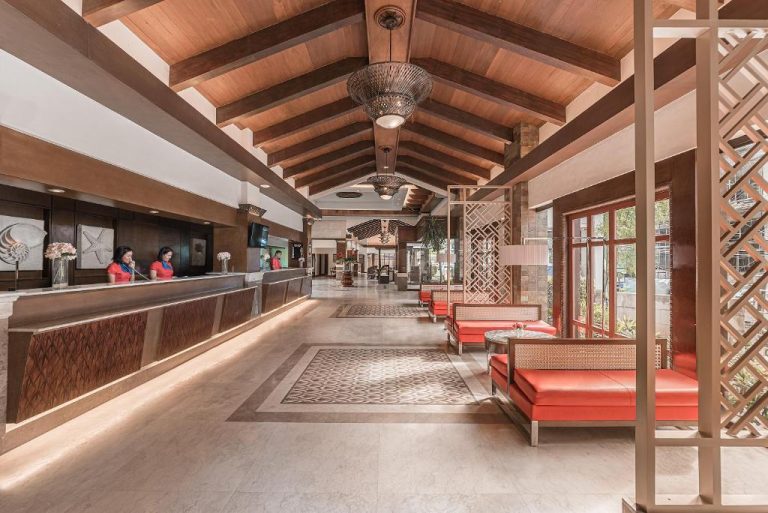 Recepción principal con techo de madera y sofás rojos del Henann Regency Resort and Spa