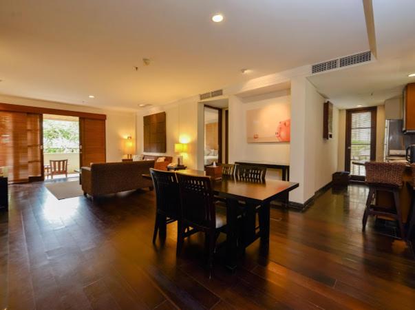 Amplio salón comedor con mesa de madera y zona de estar en suite del Ruby Nusa Dua Bali