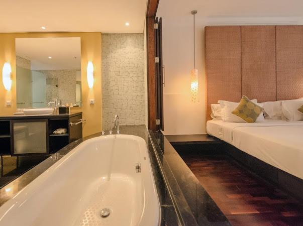 Habitación de lujo con bañera exenta y cama doble en el hotel Ruby Nusa Dua Bali