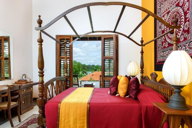 Habitación colonial con cama de dosel de madera y vistas al río en The Notary's House