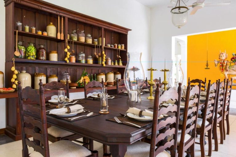 Elegante comedor colonial de The Notary's House con mesa larga de madera y alacena con especias