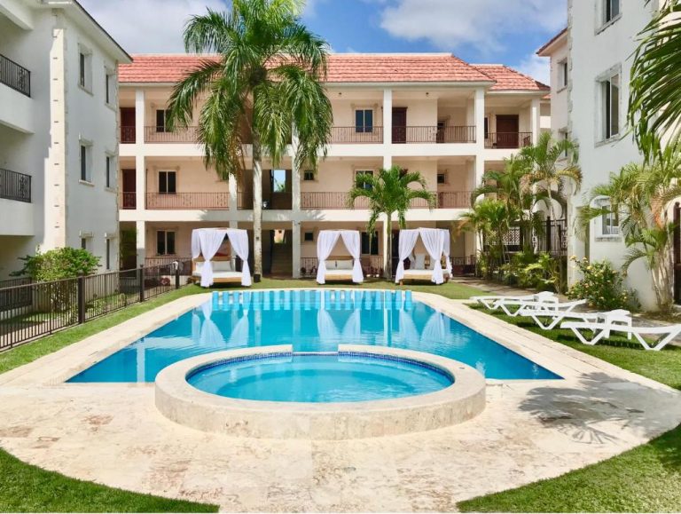 Piscina exterior con jacuzzi y cabañas de lujo del hotel Punta Cana Seven Beaches rodeada de palmeras
