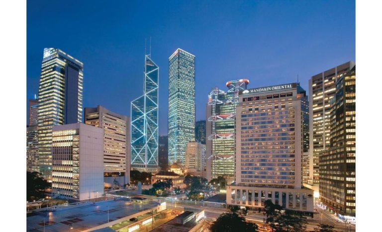 Vista nocturna del Mandarin Oriental Hong Kong rodeado del skyline financiero de la ciudad