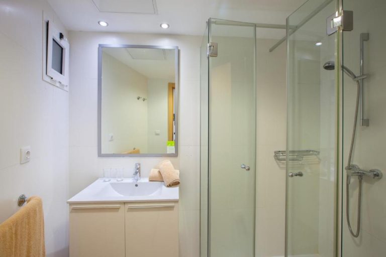 Baño moderno con ducha de cristal y lavabo blanco en el Grupotel Revoli