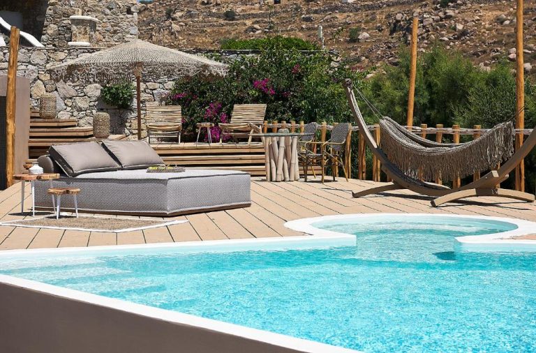 Piscina privada con terraza de madera, hamaca y tumbonas en el Palladium Hotel