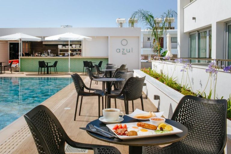Desayuno junto a la piscina exterior en el Cosmo Napa Boutique Hotel con bar Azul al fondo