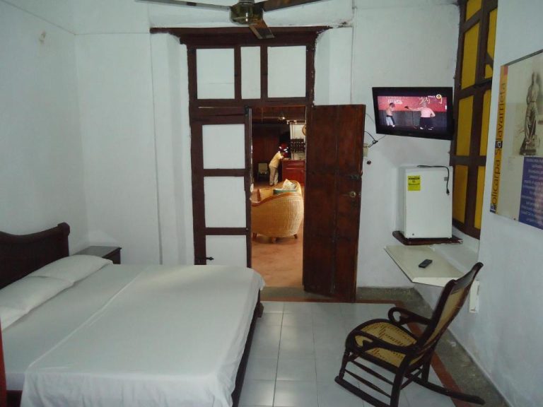 Habitación doble clásica con cama, televisor y minibar del Hotel Nueva Granada en Colombia