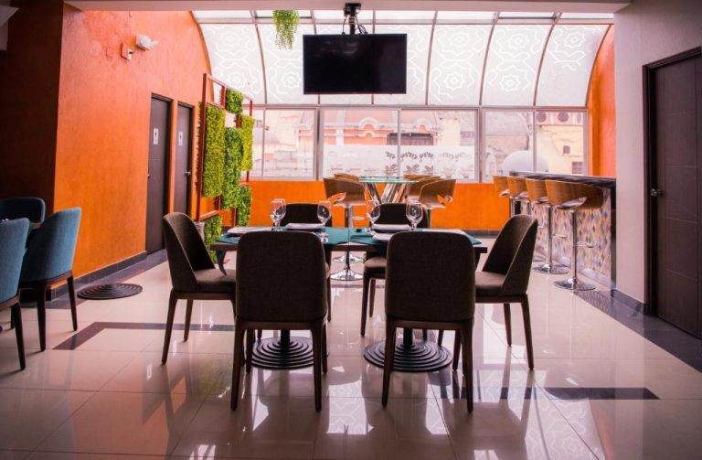 Restaurante con terraza acristalada y bar del Hotel Diamond Lima con mesas y copas de vino