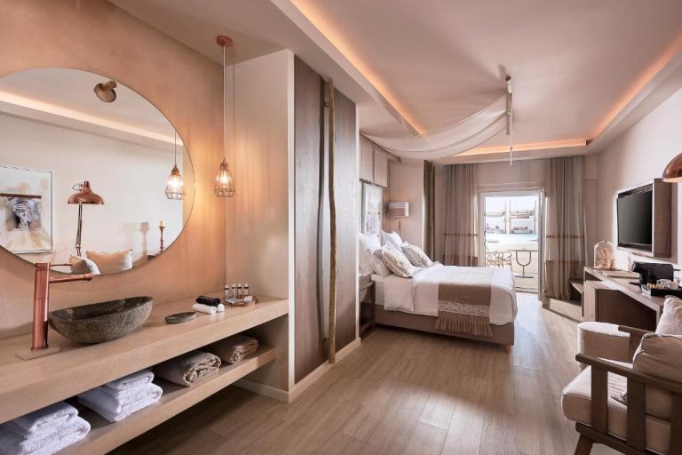 Habitación deluxe con baño abierto y lavabo de piedra en el Palladium Hotel, decoración en tonos nude