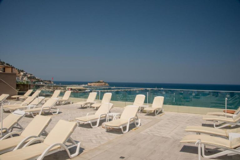 Terraza solarium con tumbonas blancas y vistas al mar mediterráneo en el Derici Hotel