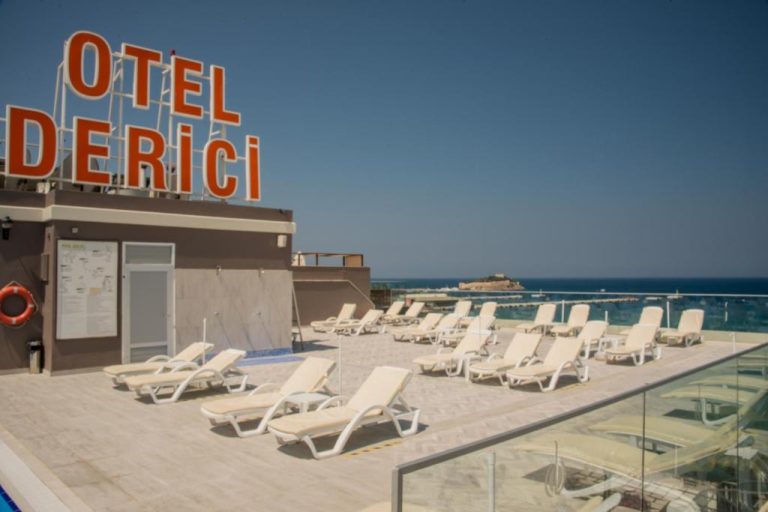 Terraza solarium con tumbonas y vistas al mar del Derici Hotel en Kusadasi