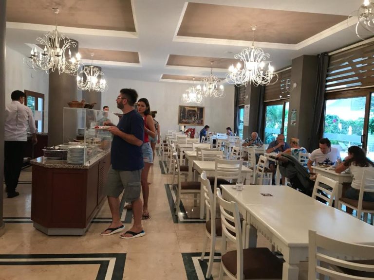 Restaurante buffet interior con mesas blancas y lámparas de araña en My Dream Hotel
