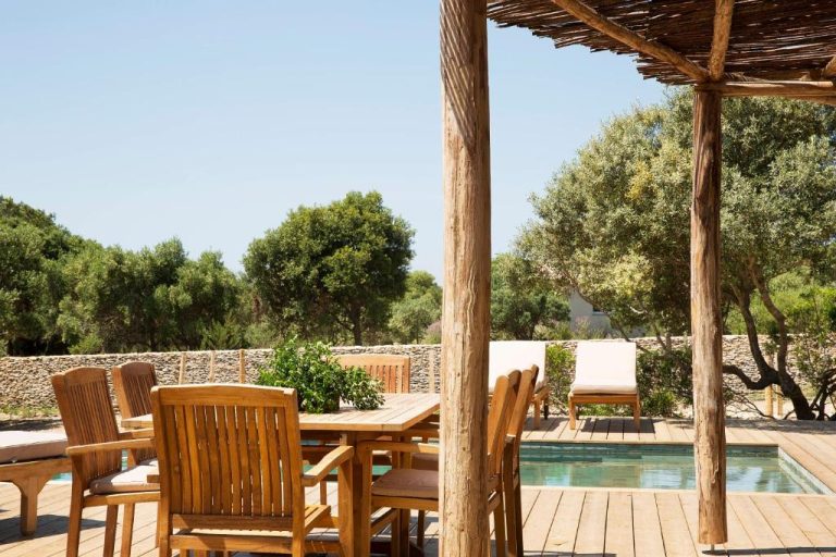 Terraza de madera con comedor exterior y piscina privada rodeada de naturaleza en hotel U Capu Biancu