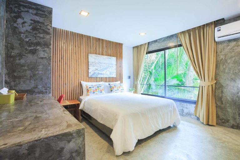 Habitación doble con cama king y ventanal con vistas a jardín tropical en In My Place Cafotel