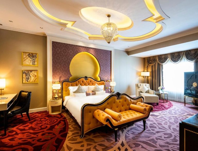 Suite de lujo con cama dorada y decoración árabe en el Ezdan Palace Hotel de Doha